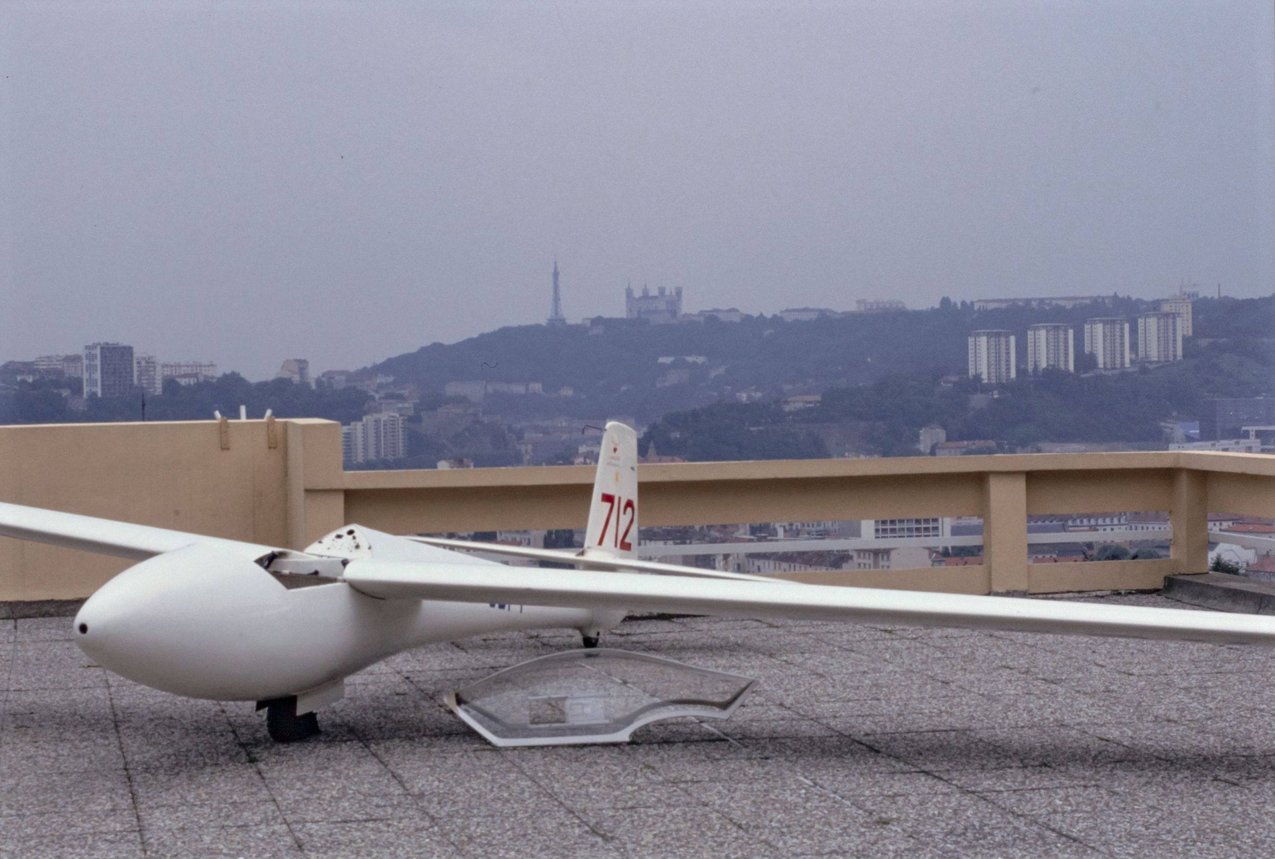 Présentation d'un planeur lors de la remise du brevet d'initiation au vol à voile, avec Fourvière en arrière-plan : photographie couleur (1992, cote 1518WP/1093)