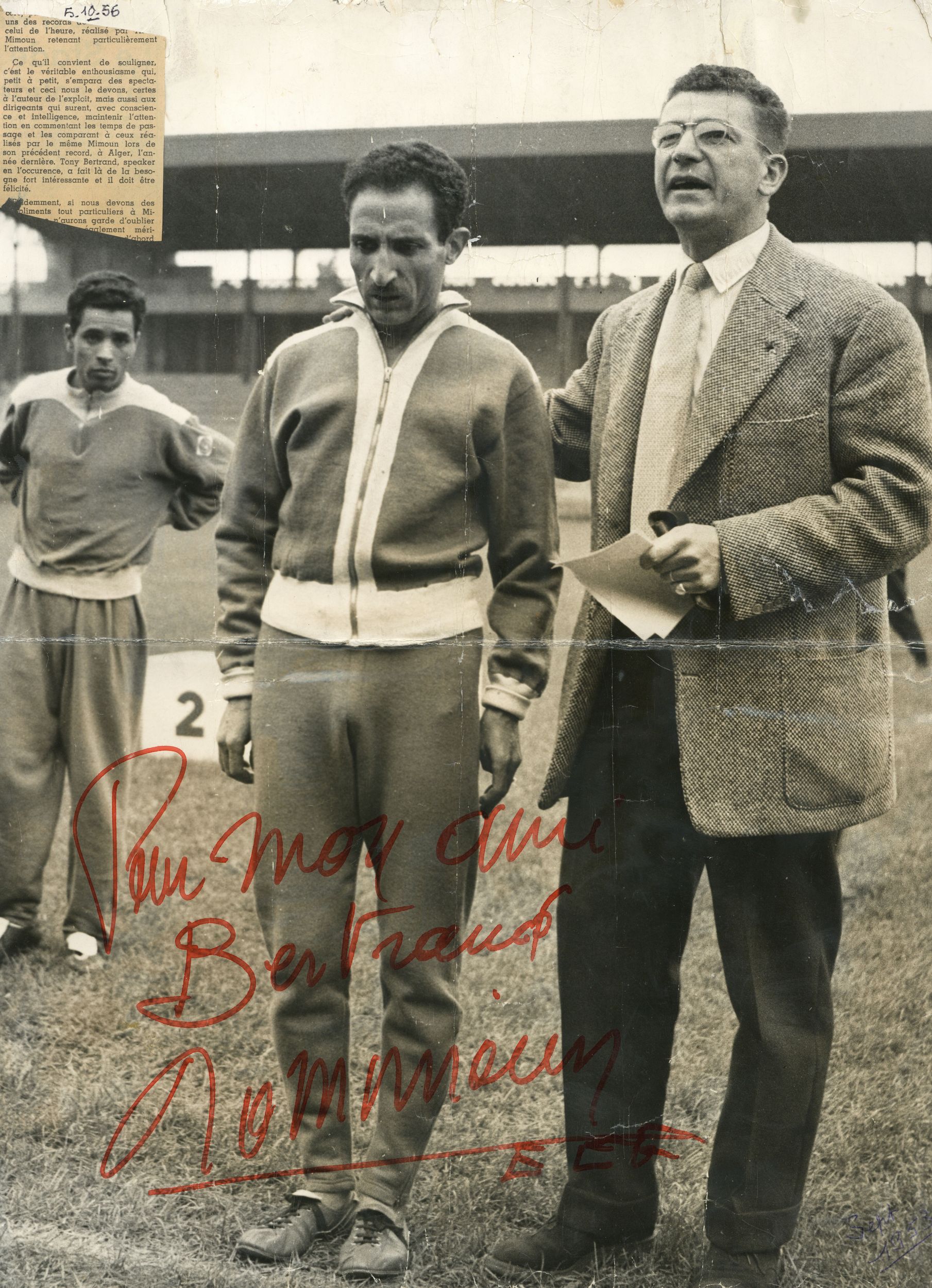 Alain Mimoun, Tony Bertrand, Abdelkrim - Tirage A3 du 5 octobre 1956 "record de l'heure à Lyon", plié, dédicacé par Alain Mimoun, avec également un fragment d'article collé en haut à gauche : photographie NB (1956, cote 362II/4)