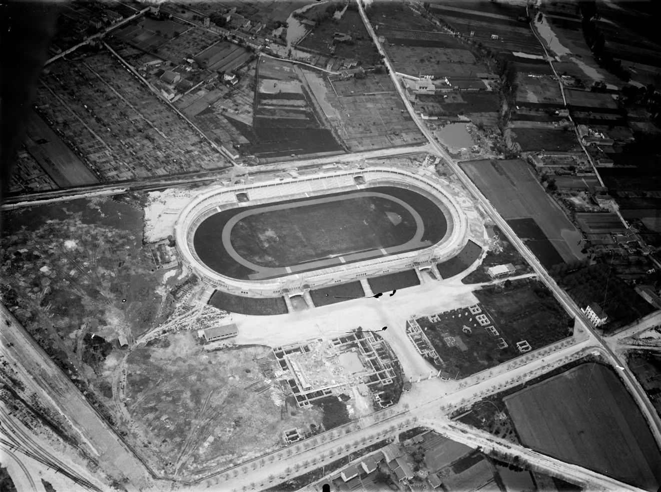 Quartier du stade de Gerland - Vue aérienne oblique du stade pour les sports athlétiques achevé et du stade nautique en construction : photographie négative NB sur verre (1935, cote 15PH/1/656)