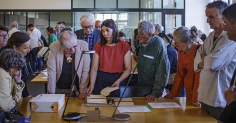 Photo de visiteurs découvrant des documents d'archives - Photo par Philippe Somnolet