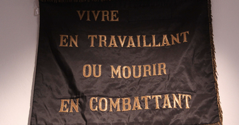 Drapeau avec l'écriture "Vivre en travaillant ou mourir en combattant"